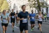 Un groupe de coureurs amateurs avance sur une rue sécurisée pendant une course.
