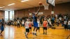Joueur en bleu effectue un tir au panier lors d'un match