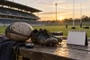 Ballon de rugby, chaussures, chronomètre et calendrier vierge au bord d’un terrain vide.