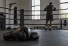 Athlète adulte non identifiable vu de dos dans un ring de boxe générique.
