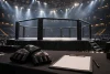 Cage de MMA vide avec gants génériques et feuille de score vierge sous les projecteurs.