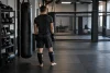 Athlète adulte non identifiable vu de dos dans une salle de MMA générique.